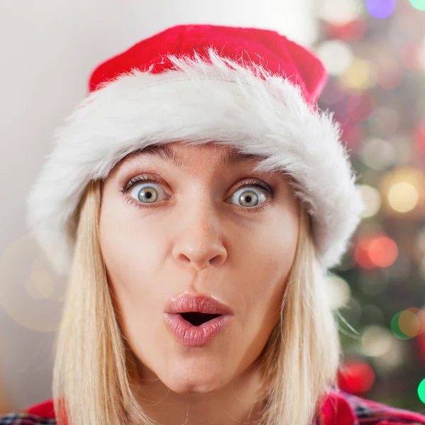 Happy surprised woman on Christmas tree background — Stock Photo, Image