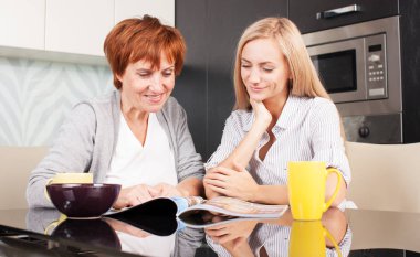 Anne ve kızı evde dergi okuyun.