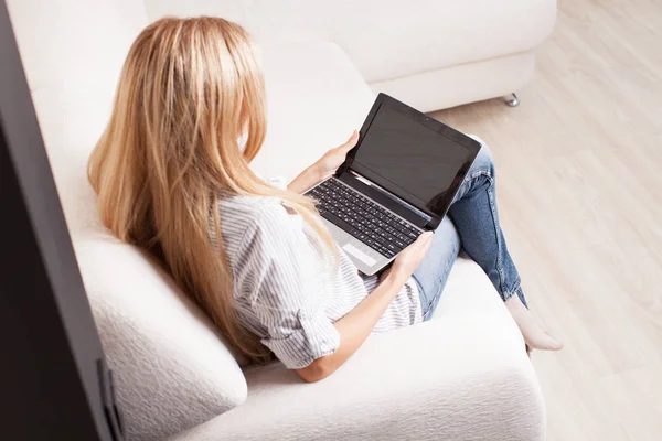 Donna sul divano con laptop — Foto Stock