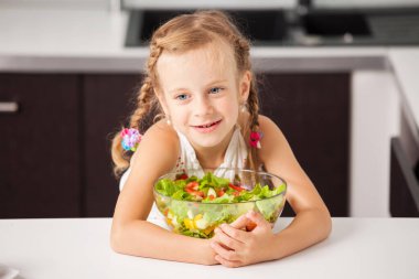 sebze salatası yiyen küçük kız