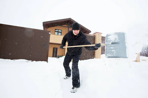 Man cleans snow shovel — Stock Photo, Image