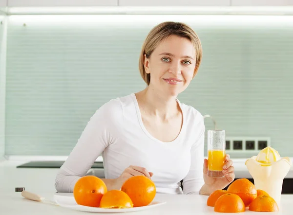 Adult woman cooking orange juice — Stock Photo, Image