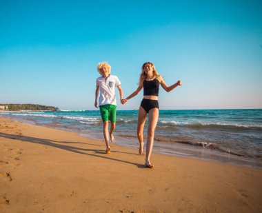 Eğleniyor kumsalda güneşli günde mutlu genç çift