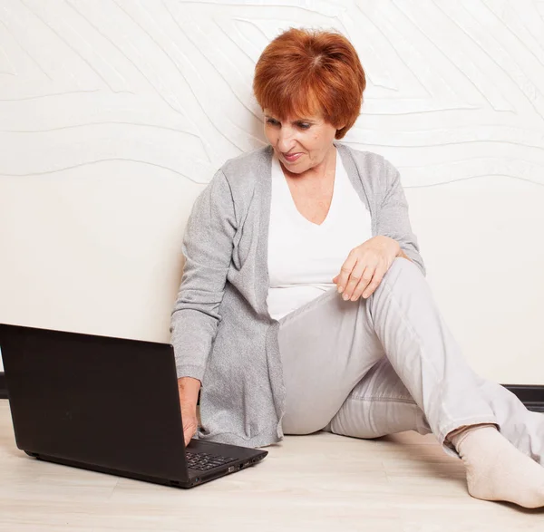 Kobieta siedzi na podłodze z laptopa — Zdjęcie stockowe