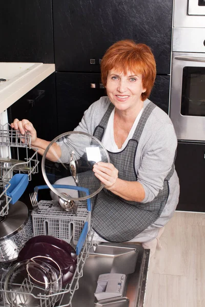 Femme pliant la vaisselle dans le lave-vaisselle — Photo