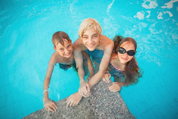 Crianças se divertindo na piscina ao ar livre — Fotografia de Stock