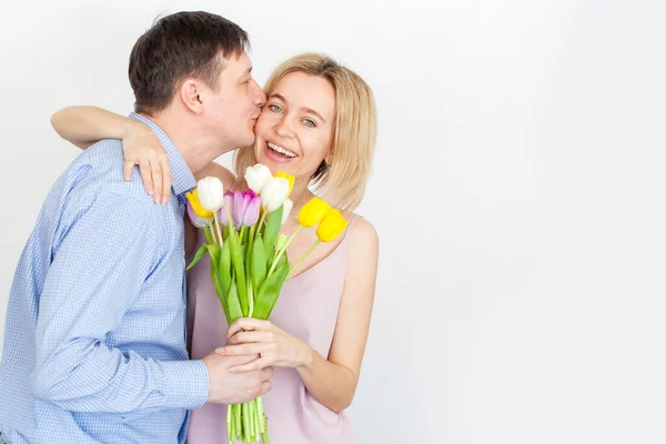 Man gives a bouquet of flowers to woman