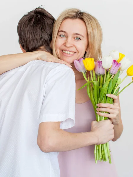 Filho dá a mãe um buquê de flores para o feriado — Fotografia de Stock