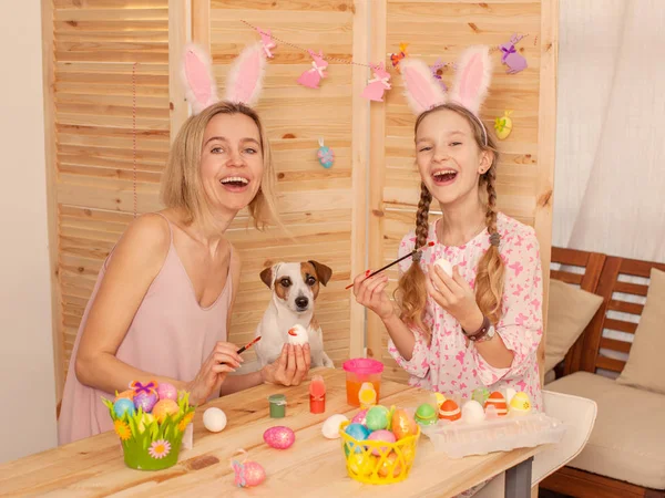 Femme heureuse avec enfant peinture oeufs de Pâques — Photo