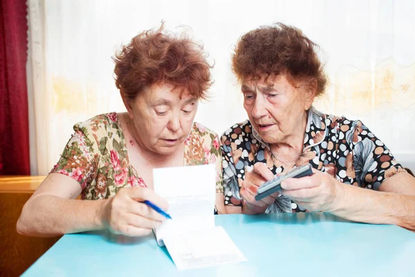 Duas idosas consideram recibos — Fotografia de Stock