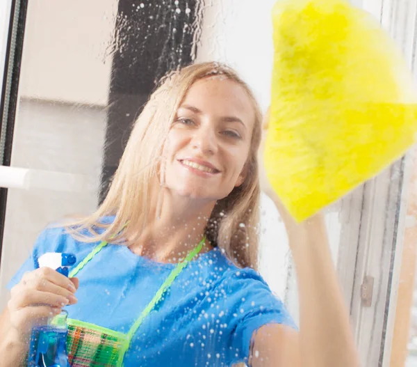 Young woman washing window