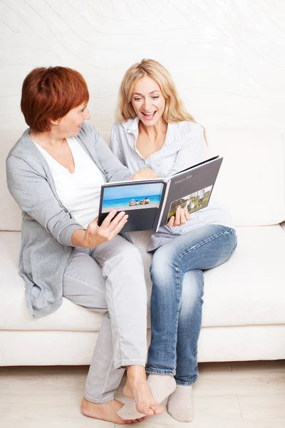 Mother and daughter looking photo book — Stock Photo, Image