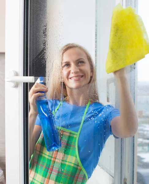 Young woman washing window — Stock Photo, Image