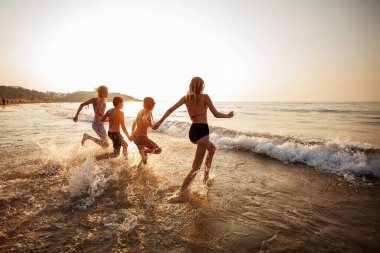 Mutlu genç peaple güneşli bir günde sahilde eğleniyor.