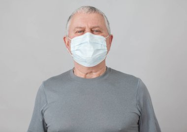 Sağlık maskeli son sınıf öğrencisi gri arka planda izole edildi