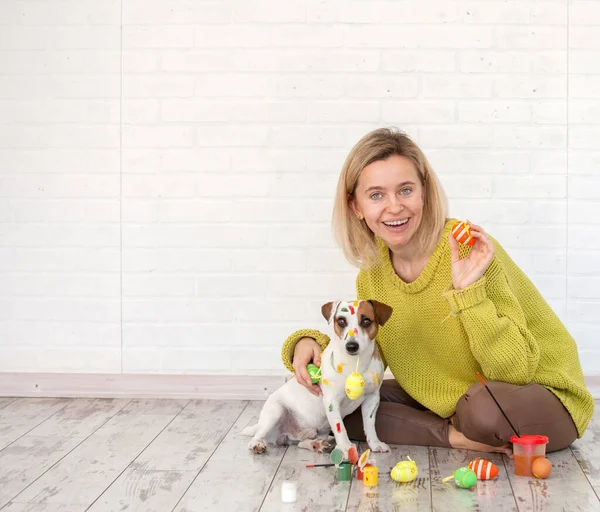 Frau und Hund malen Ostereier an — Stockfoto