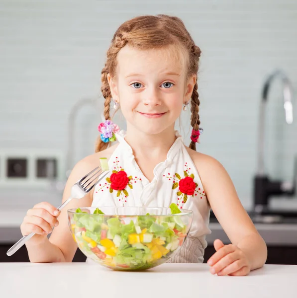 Маленькая девочка ест овощной салат — стоковое фото