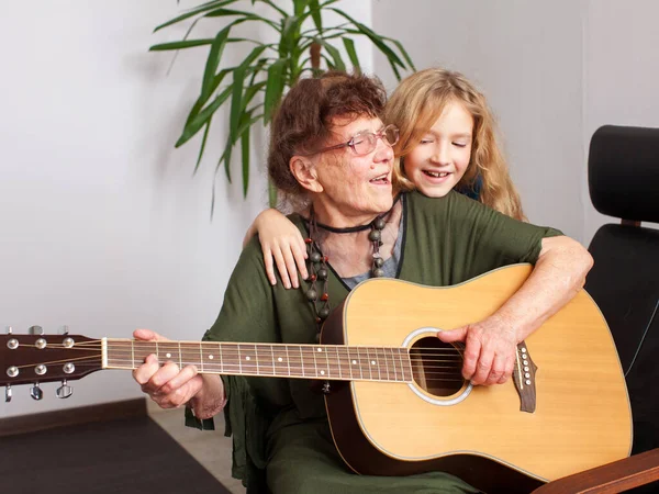 90 jaar oud grootmoeder naar de gitaar te spelen — Stockfoto