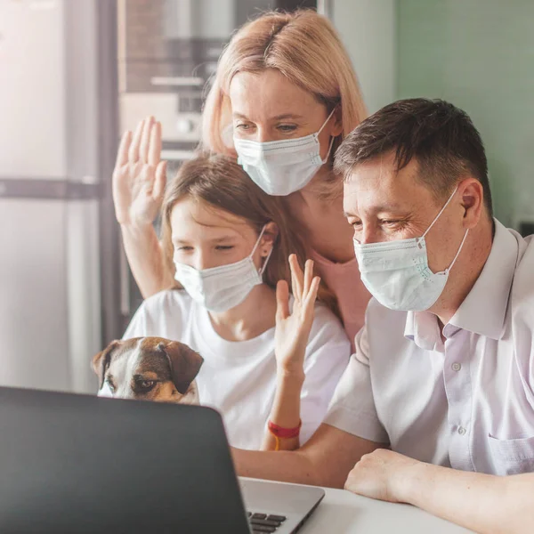Boldog család keres laptop otthon maszkban alatt a pandémiás koronavírus — Stock Fotó