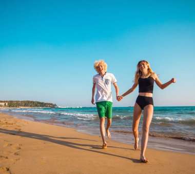 Eğleniyor kumsalda güneşli günde mutlu genç çift