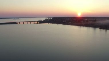 Bridge kış günbatımı, havadan görünümü ile büyük donmuş göl üzerinde uçuş.