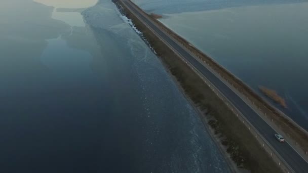Let nad silnici v zamrzlém jezeře na letecký pohled na západ slunce, zima. — Stock video