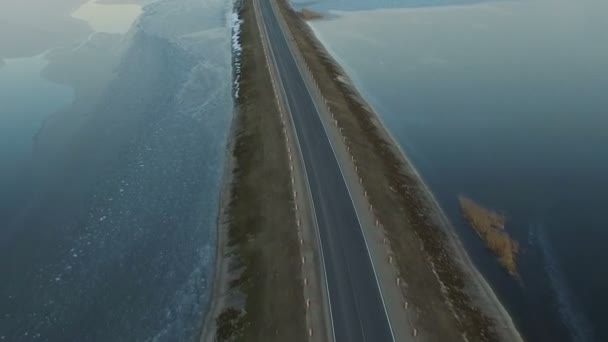 Flyg över vägen i den frusna sjön på vintern på solnedgången, aerial view. — Stockvideo