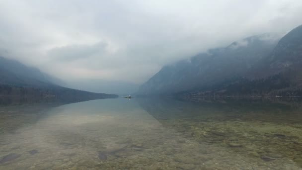 4K. Increíble lago Bohinj en el tiempo brumoso, piedras y el pájaro, vista panorámica. Julian Alps, Parque Nacional de Triglav, Eslovenia, Europa. Tiempo de invierno — Vídeo de stock