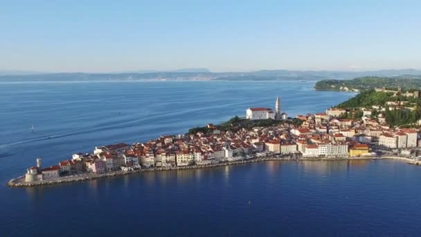 Flight over old city Piran in Slovenia, aerial panoramic view with old houses, St. George 's Parish Church, fortress and the sea — стоковое видео