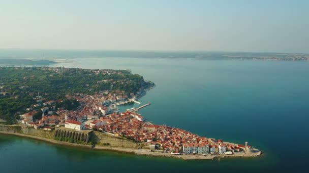 4K. Voo sobre a cidade velha Piran pela manhã, vista panorâmica aérea superior com casas velhas, Praça Tartini, Igreja Paroquial de São Jorge, fortaleza e marina . — Vídeo de Stock