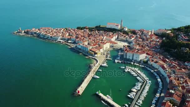 4K. Voo sobre a cidade velha Piran pela manhã, vista panorâmica aérea com Praça Tartini, Igreja Paroquial de São Jorge, marina e casas antigas — Vídeo de Stock