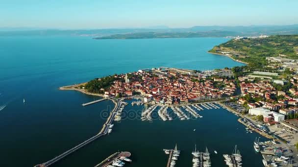 4K. Voo sobre a cidade velha de Izola, na Eslovênia, vista panorâmica aérea com marina ao pôr do sol. Costa do mar Adriático. Península da Ístria — Vídeo de Stock