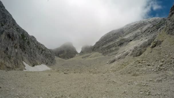 4K. Time Lapse in mountains with changeable weather: sun and deep clouds. People are walking and hiking around. Slovenia, Julian Alps, Soca Valley, Bovec district, Kanin Mountains. — Stock Video