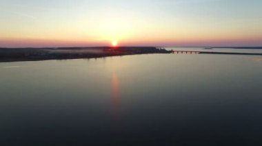 4 k. uçuş bridge kış günbatımı, havadan görünümü ile büyük donmuş göl üzerinde.