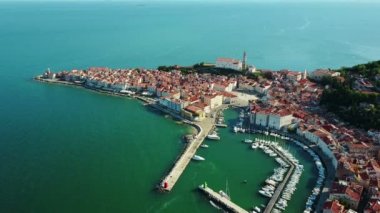 4 k derleme Video. Eski şehirde Piran sabah, Tartini Meydanı, St. George's Parish Kilisesi, marina ve eski evlerin çatıları ile havadan görünümü üzerinde uçuş. 