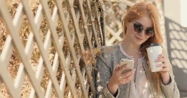 Güzel kız masaj üstünde belgili tanımlık hareket eden telefon ve içki kahve yazma