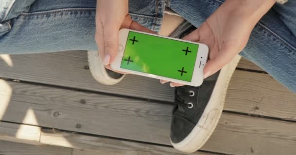 Chica buscando smartfone con pantalla verde . — Vídeos de Stock