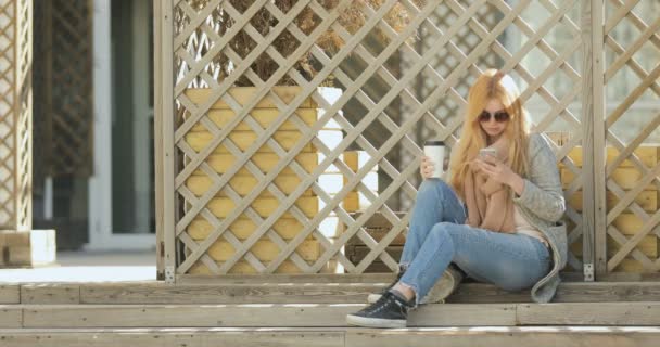 Elegante mujer hermosa mensajes de texto en el teléfono inteligente en la ciudad — Vídeos de Stock