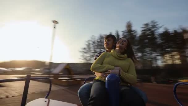Романтична пара катається на каруселі разом — стокове відео