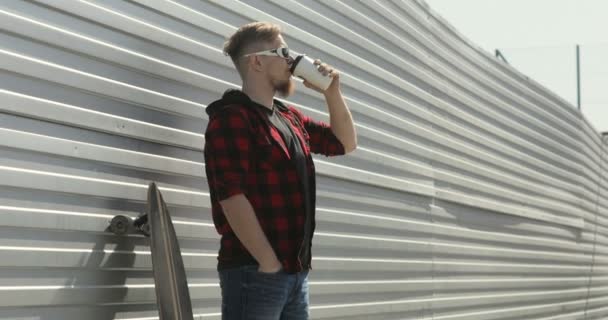 Jovem ficar com longboard e beber café — Vídeo de Stock