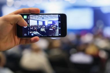 Seyirci bir iş toplantısında. Kişi alma fotoğraf ile akıllı telefon.