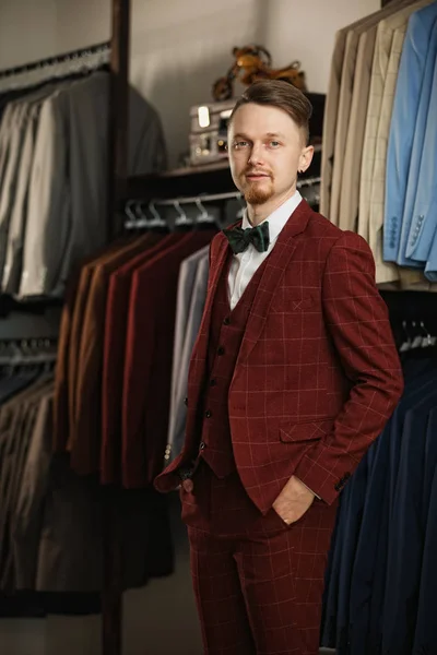 Negocios, personas, ropa de hombre, venta y concepto de ropa - joven empresario feliz sobre fondo de la tienda de ropa — Foto de Stock