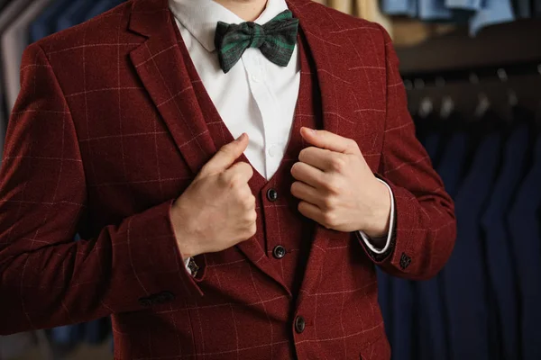 Joven hombre de negocios barbudo guapo en traje clásico. El hombre lleva una chaqueta. Está en la sala de exposición, probándose ropa, posando. Publicidad foto — Foto de Stock