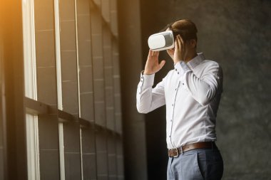 Sanal gerçeklik giyen genç adam modern iç mekan tasarımları içinde gözlük. Vr ile Smartphone kullanarak kulaklık gözlükler. Yatay, fişekleri etkisi, arka plan bulanık