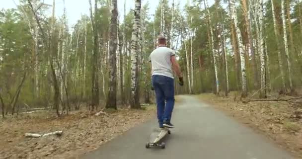 Kerl auf seinem Longboard-Skate. Kamerafahrt — Stockvideo
