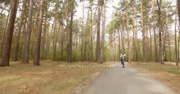 Mann auf seinem Longboard-Skate in einem Park. Kamerafahrt — Stockvideo