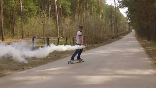 Guy schaatsen op logboard in een forest met een kleur rook granaat, slow-motion — Stockvideo