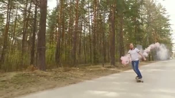 Guy skate på logboard i en skog med en färg rök granat, Slowmotion — Stockvideo