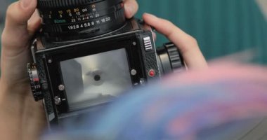 Bir hippi kız, yakın çekim, film kamerası elinde eski orta format fotoğraf makinesi