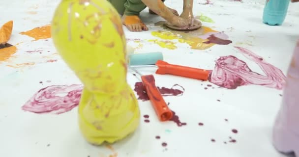 Criança ocupada cobrindo seu corpo com tinta colorida — Vídeo de Stock